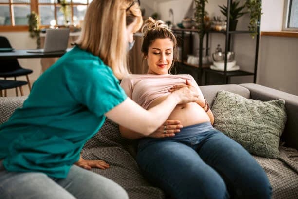 A caregiver supporting an expecting parent at home